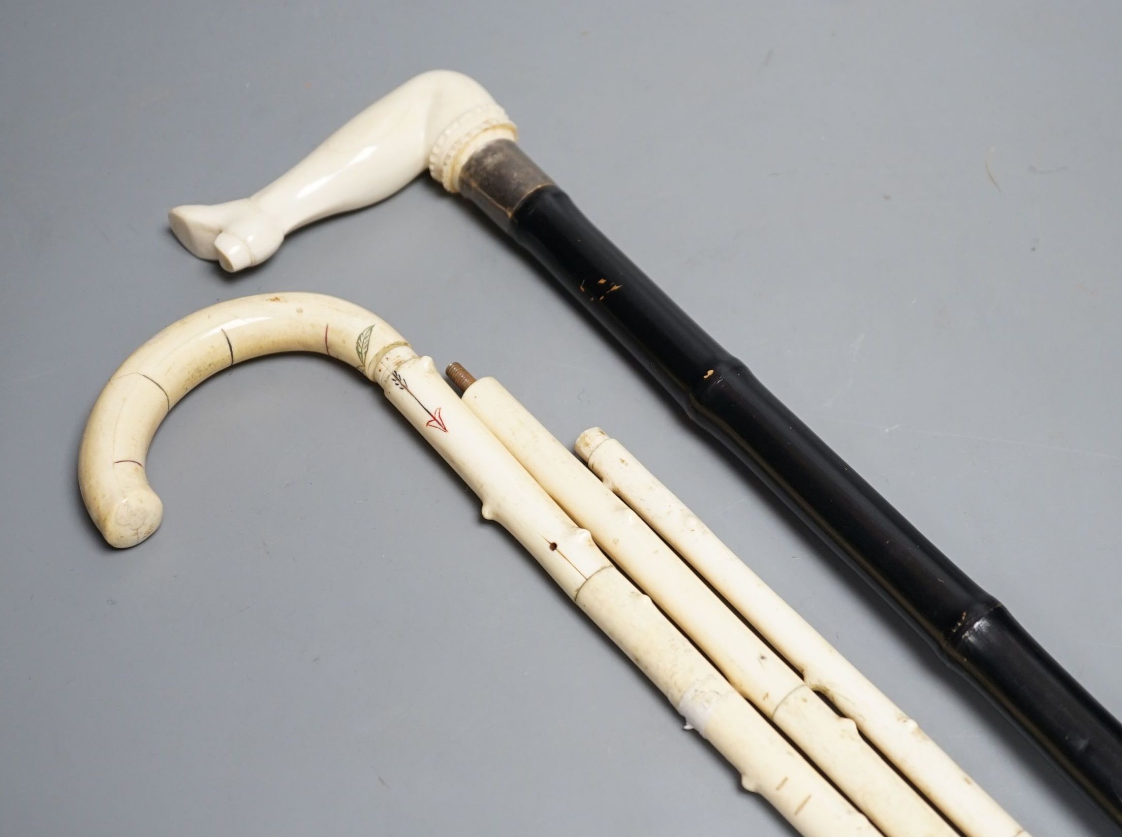 A silver mounted ivory handled ‘leg and shoe’ walking cane (88cm) and a sectional ivory walking cane, sections missing (a.f)